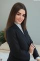 A woman in a business suit posing for a picture.