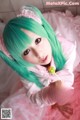 A woman with green hair holding a lollipop in her hand.