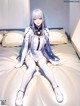 A woman sitting on top of a bed in a room.