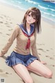 A girl in a school uniform sitting on the beach.