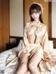 A woman in a kimono sitting on a bed.